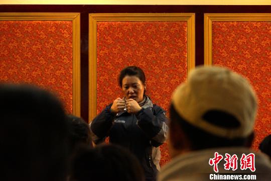 西藏聋人协会主席吾根卓嘎用手语向听力残疾人士介绍筛查时需要注意的事项。　江飞波 摄